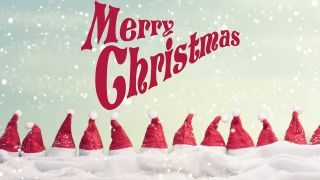 Viele rot-weiße Weihnachtszipfelmützen in Reihe nebeneinander, darüber der Schriftzug "Merry Christmas" (Quelle: IMAGO | Shotshop)