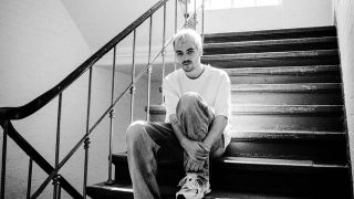 Der Musiker Tuffy sitzt in einem Treppenhaus. Das Bild ist schwarz weiß. | Quelle: Marla Kästle