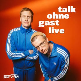 Moritz Neumeier und Till Reiners stehen in Trainingsanzügen vor einer roten Wand | Quelle: Oschatz Management