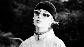 Schwarz-weiß Portrait der Musikerin NESS. Sie trägt eine Sonnenbrille und eine Mütze. | Quelle: NESS
