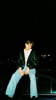 JAS sitzt mit schwarzer Lederjacke in der Nacht auf einem Geländer | Quelle: Universal