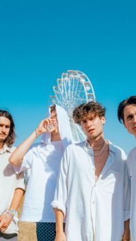 Die Band Jeremias steht vor einem weißen Riesenrad vor türkisblauem Himmel. (Quelle: Universal Music | Lucio Vignolo)