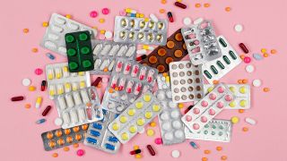 Viele bunte Tabletten und Blister auf einem rosa Hintergrund (Quelle: IMAGO / imagebroker)