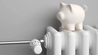 Ein Heizkörper mit Thermostat und Sparschwein (Quelle: IMAGO | Zoonar)