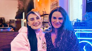 Musikerin Rubi und Fritzin Jule Kaden sitzen in einem Café neben einem blauen neon-Radio-Schild und lächeln in die Kamera. | Foto: Fritz (Michael Mahler)