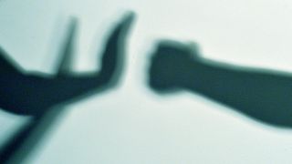 Symbolbild "Gewalt": Die Schatten zweier Hände und Fäuste vor einer Wand. (Quelle: dpa/Maurizio Gambarini)