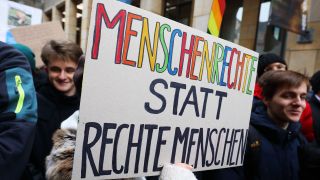 Ein Demo-Plakat mit der Aufschrift "Menschenrechte statt rechte Menschen" (Quelle: IMAGO | Müller-Stauffenberg)