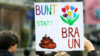 Ein Schild bei einer Demo mit der Aufschrift "Bunt statt braun" (Quelle: IMAGO | Müller Stauffenberg)