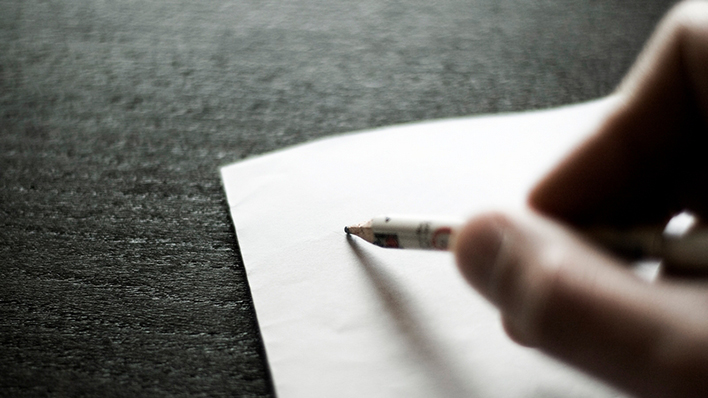 Eine Hand setzt an, um etwas auf ein weißes Blatt Papier zu schreiben (Foto: steffne l photocase.com)
