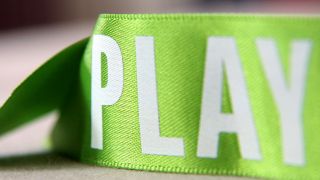 Ein grünes Stoffband mit der Aufschrift "PLAY" (Foto: *bonsai* l photocase.com)