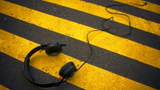 Kopfhörer liegen auf schwarz-gelbem Zebrastreifen (Foto: complize l photocase.com)
