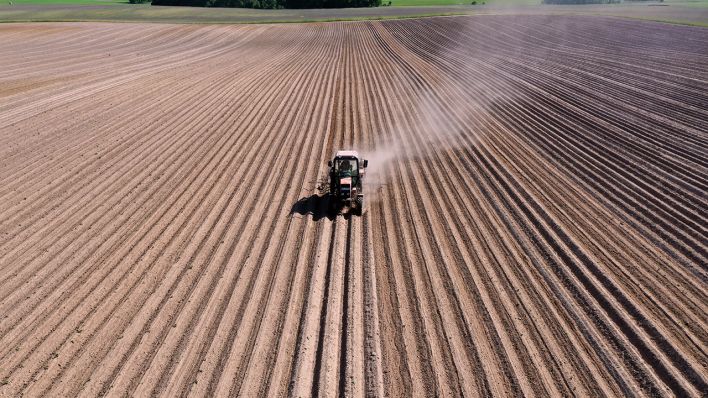 Ein Traktor zieht bei der Bearbeitung eines Kartoffelfeldes eine Staubfahne hinter sich her © imago images/Jochen Eckel Ein Traktor zieht bei der Bearbeitung eines Kartoffelfeldes eine Staubfahne hinter sich her © imago images/Jochen Eckel